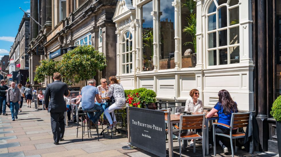 People sitting outside a pub eating and drinking